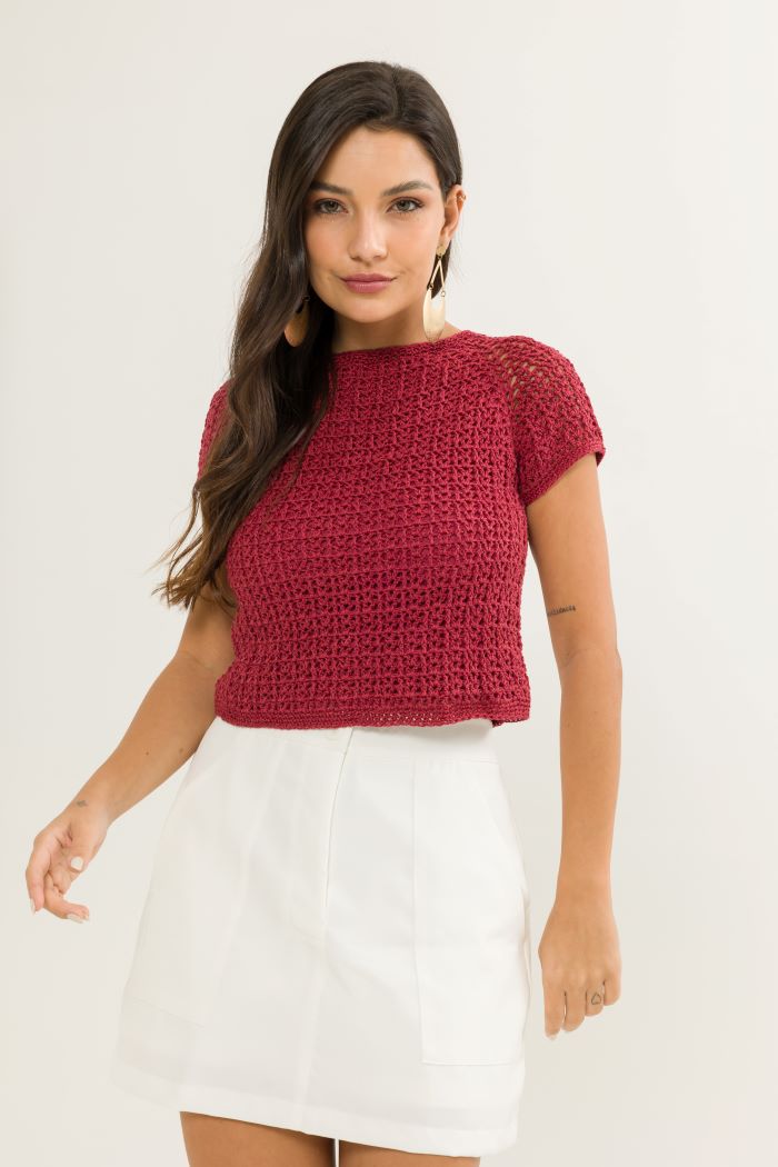 Circulo ANNE - 100% mercerized Cotton Yarn, 500m / 147g - Woman wearing a red knitted top and white skirt on a plain background