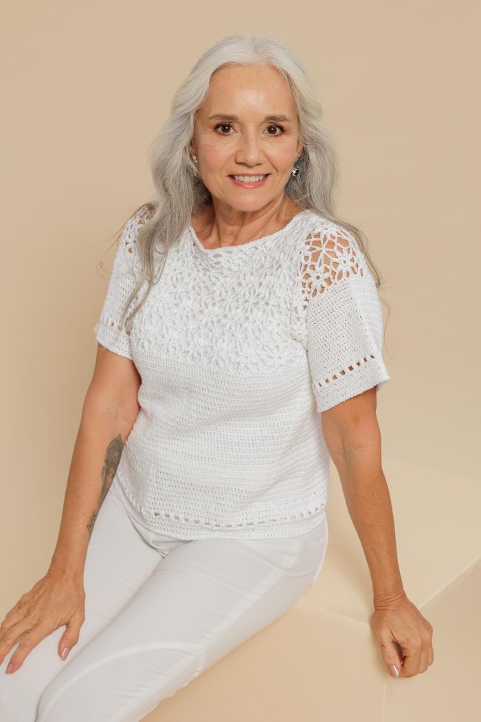 Circulo Clea 100% Cotton Yarn, 1000m/151 gr - Woman wearing a white crochet top and pants on a beige background