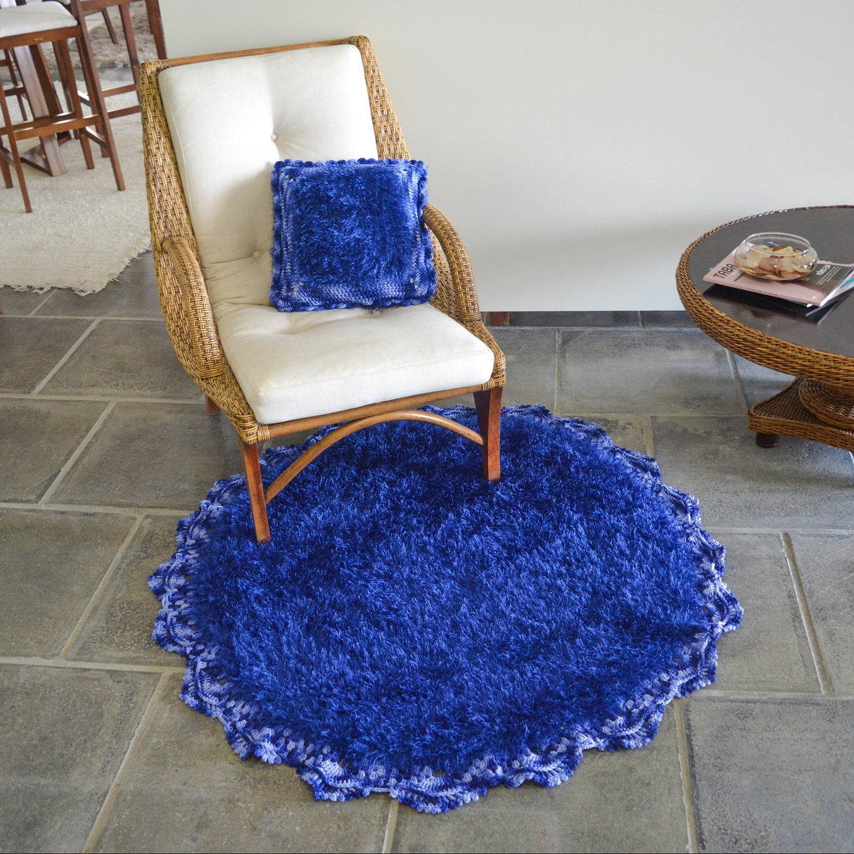 Circulo Natural Luxury Decor - Fluffy  Effect Yarn, 180 m / 280 g - Blue shaggy rug on a stone floor with a chair and table in the background.